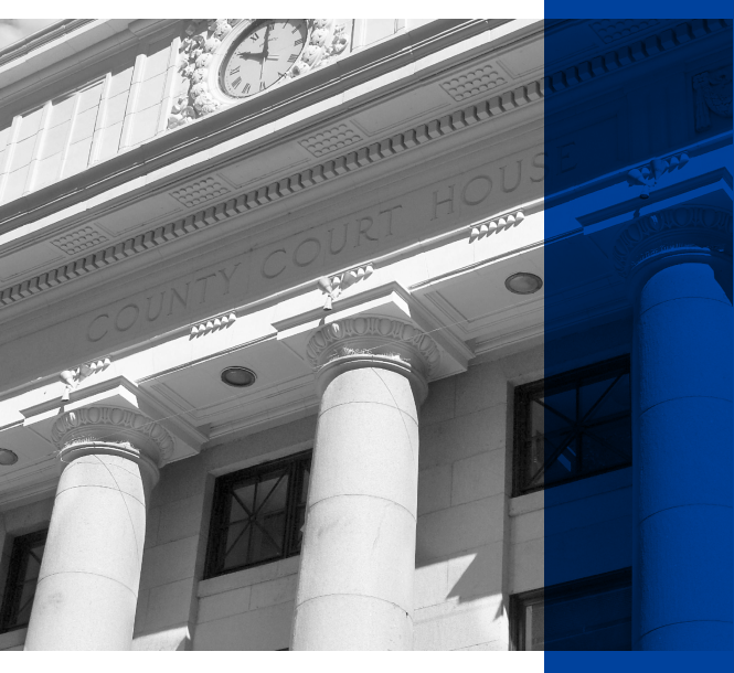 Courthouse image with blue overlay_Access A black and white image of a courthouse.