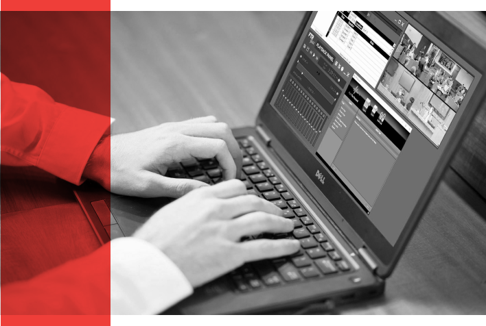 A black and white image of a person typing on a laptop keyboard