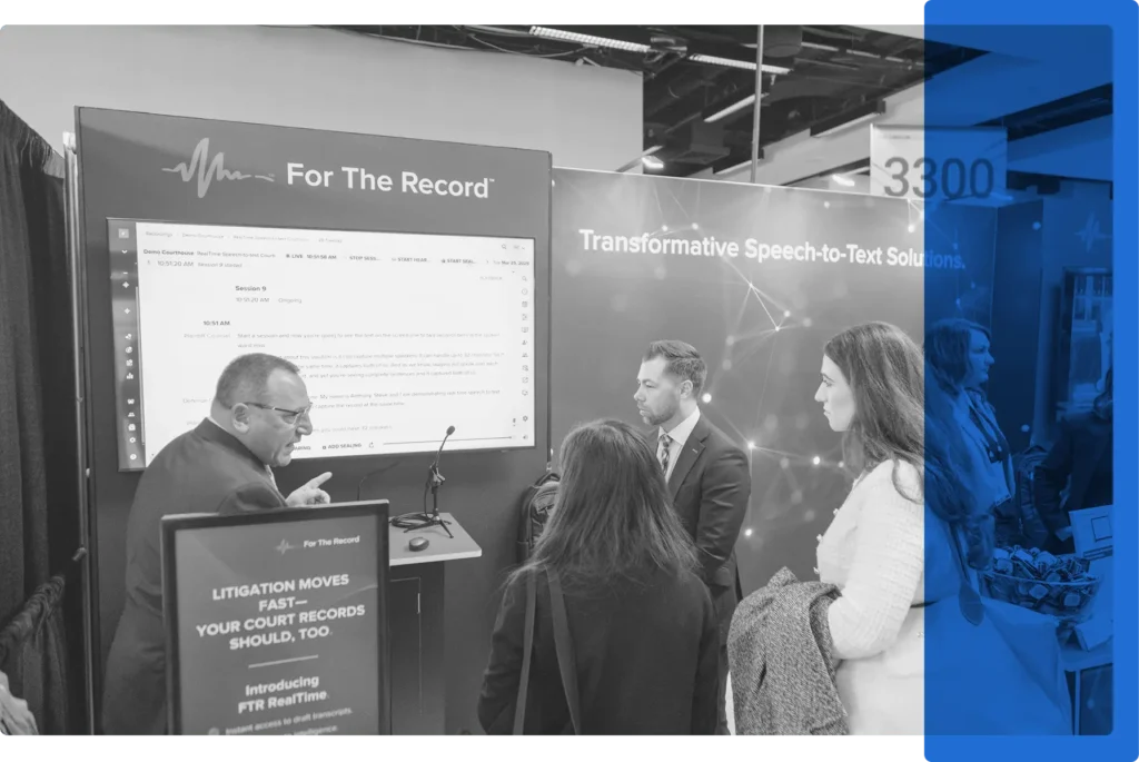People gathered around a speech-to-text demonstration in a conference booth