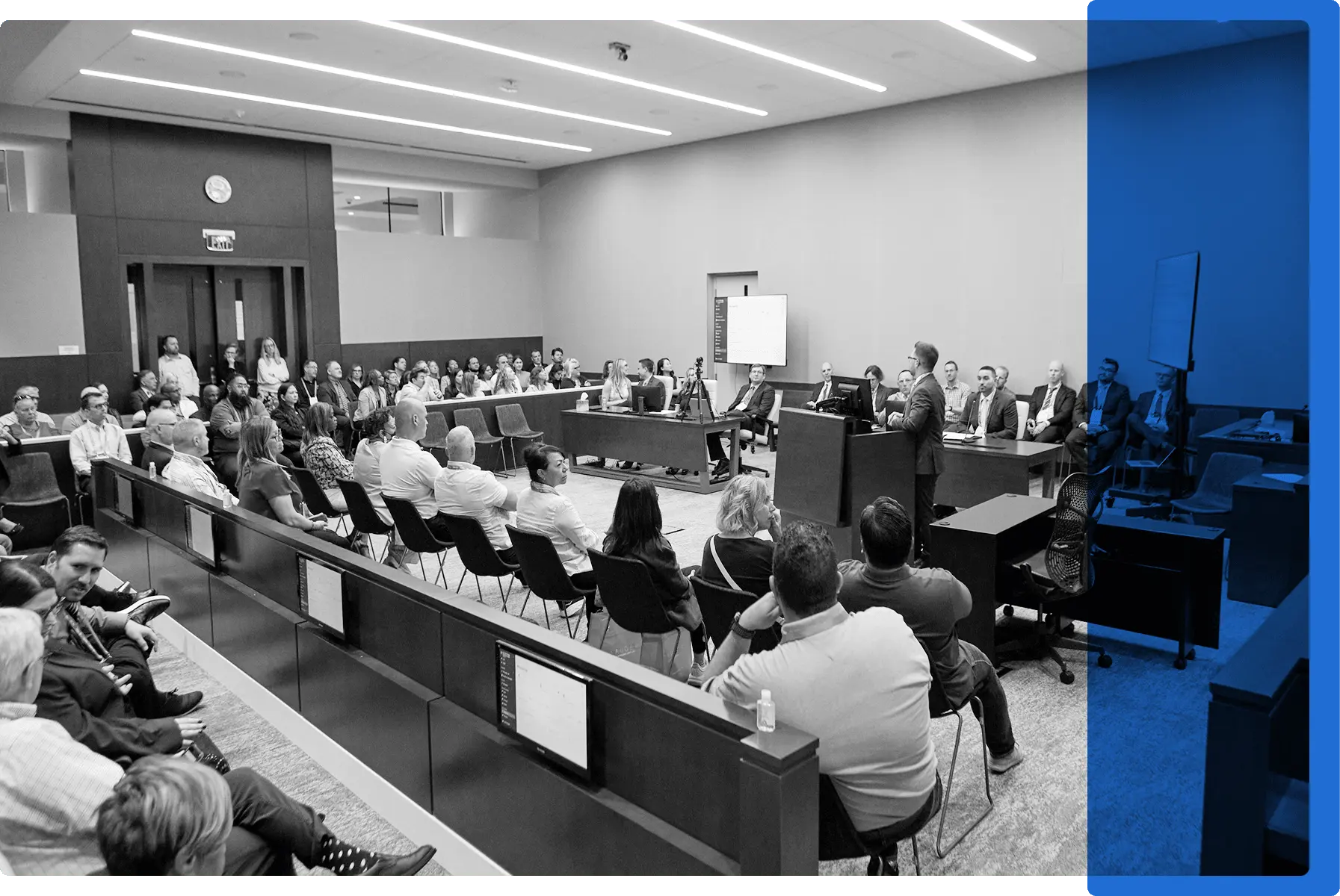 A courtroom filled with people listening to a technology demonstration
